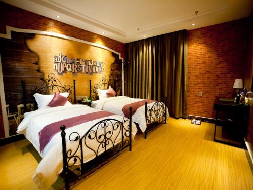 a bedroom with two beds and a brick wall at Thank Inn Plus Hotel Guangxi Liuzhou Luzhai County Bus Station in Liuzhou