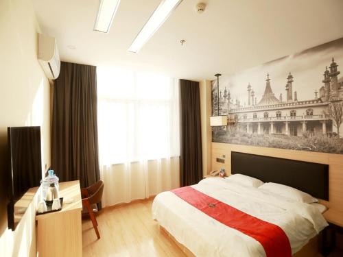 a bedroom with a bed and a painting on the wall at Thank Inn Plus Hotel Shandong Zaozhuang Tengzhou Parallel Road Qinghe Shangcheng Community in Zaozhuang