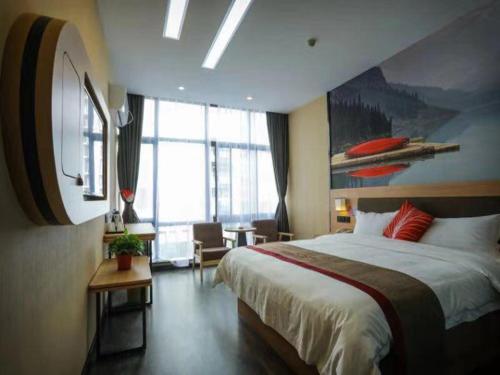 - une chambre avec un grand lit et une grande fenêtre dans l'établissement Thank Inn Plus Hotel Anhui Tongling Tongguan District Xihuchuncheng, à Yüan-hsien-ch'eng