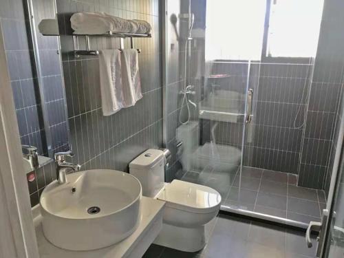 een badkamer met een wastafel, een toilet en een douche bij Thank Inn Plus Hotel Hubei Xiaogan Nanda Economic Development Zone Tianxia Mansion in Xiaogan