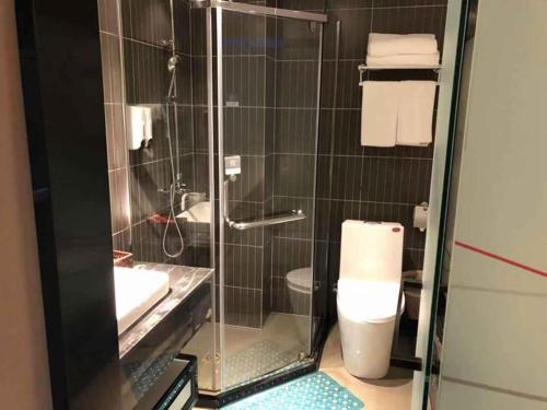 a bathroom with a shower and a toilet and a sink at Thank Inn Plus Hotel Shandong Zibo Zhangdian District Jinjing Avenue Wanxianghui in Zibo