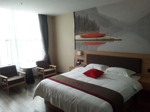 sypialnia z dużym łóżkiem i czerwoną poduszką w obiekcie Thank Inn Plus Hotel Anhui Xuancheng Xuanzhou District Shengshiyujing w mieście Xuancheng