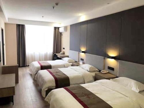 a hotel room with three beds and a large window at Thank Inn Plus Hotel Hebei Shijiazhuang Zhengding New District International Small Commodity City in Shijiazhuang