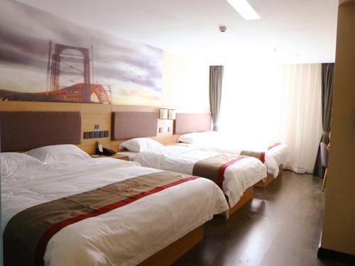um quarto de hotel com três camas e um quadro na parede em Thank Inn Plus Hotel Shanxi Jinzhong Yuci District Yingbin West Street Yinhaixinyue em Jinzhong