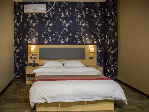 - une chambre avec un grand lit et un mur noir dans l'établissement Thank Inn Plus Hotel Jiangsu Huaian Qingpu District Evergrande, à Huai'an