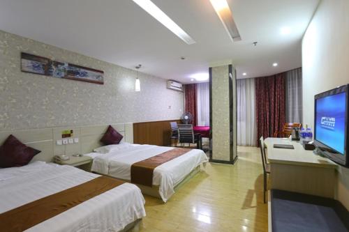 a hotel room with two beds and a flat screen tv at Thank Inn Plus Hotel Guangxi Liuzhou Luzhai County Bus Station in Liuzhou