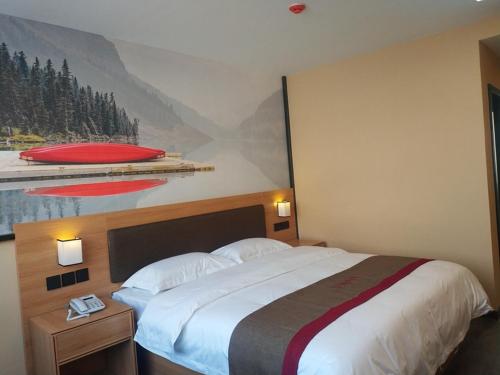 a bedroom with a large bed with a painting on the wall at Thank Inn Plus Hotel Shandong Rizhao Ju County Chengyang South RoadHospital of Chinese Traditional Medicine in Rizhao