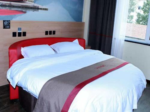 1 cama grande con cabecero rojo en un dormitorio en Thank Inn Plus Hotel Shandong Taian Xintai City Qinglong Road, en Zhaizhen