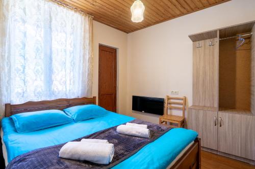 a bedroom with a bed with two towels on it at Guest House Nikala in Mestia