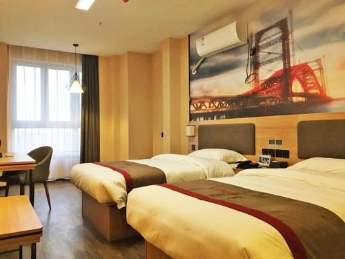 a hotel room with two beds and a painting on the wall at Thank Inn Plus Hotel Henan Anyang Longan District Zhongzhou Road in Anyang
