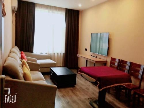 a living room with a couch and a television at Thank Inn Plus Hotel Hebei Baoding Lixian County Liwu Street in Baoding