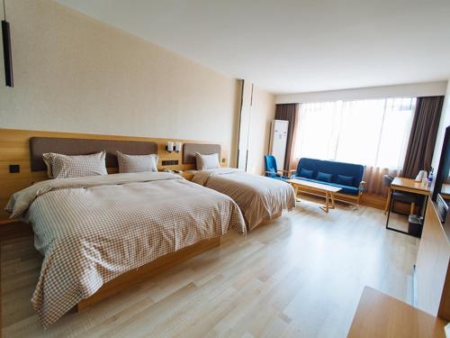 a hotel room with two beds and a couch at Up And In Anhui Wuhu Anhui University of Engineering in Wuhu
