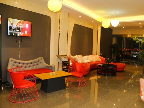 - un salon avec des chaises rouges et un canapé dans l'établissement Thank Inn Plus Hotel Guangxi Hezhou Zhaoping County Huangyao Town, à Gongqiao
