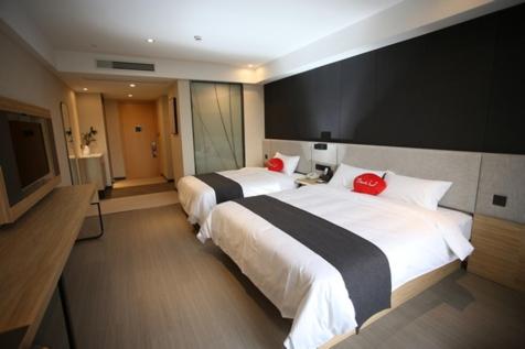 a hotel room with two beds and a flat screen tv at Thank Inn Plus Jiangsu Zhenjiang Jiangkou District Hongdou Square in Zhenjiang