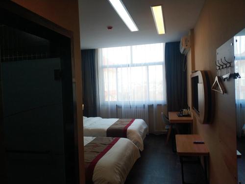 a hotel room with two beds and a window at Thank Inn Plus Hotel Shandong Rizhao Ju County Chengyang South RoadHospital of Chinese Traditional Medicine in Rizhao