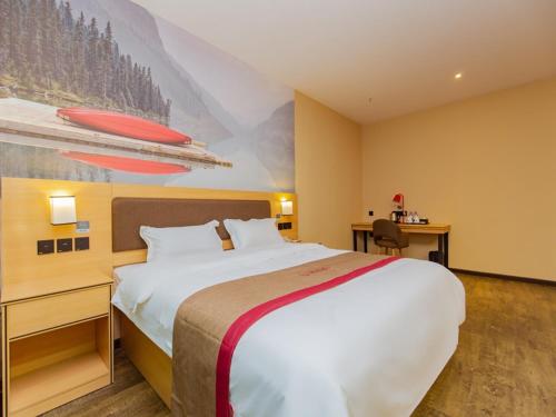 a hotel room with a large bed and a painting at Thank Inn Plus Hotel Sichuan Chengdu Jianyang Dongcheng Huafu in Chengdu