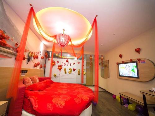 a bedroom with a red bed and a tv at Thank Inn Plus Hotel Hebei Cangzhou Botou Jinji Logistic Park in Cangzhou
