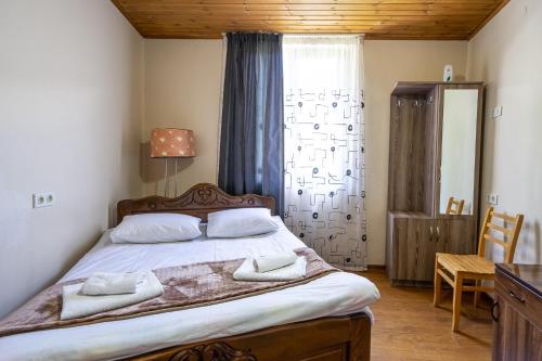 a bedroom with a bed with two towels on it at Guest House Nikala in Mestia