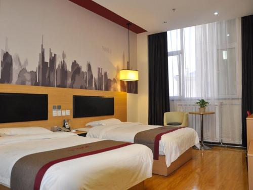 a hotel room with two beds and a tv at Thank Inn Plus Hotel Gansu Pingliang Kongtong District Fengshou Road in Pingliang