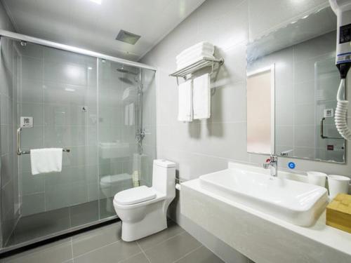 a bathroom with a toilet and a sink and a shower at Up And In Shandong Qingdao Jiaozhou Lanzhou East Road New Bus Station in Qingdao