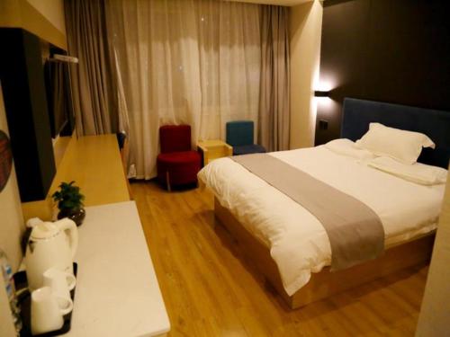 ein Hotelzimmer mit einem Bett und einem Stuhl in der Unterkunft Thank Inn Plus Hotel Shandong Jinan Jiyang HuaYang Road in Jiyang