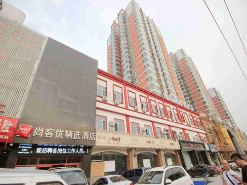 un edificio en una ciudad con coches aparcados en la calle en Thank Inn Plus Hotel Hebei Handan Hanshan District Fu Southeast Street, en Handan