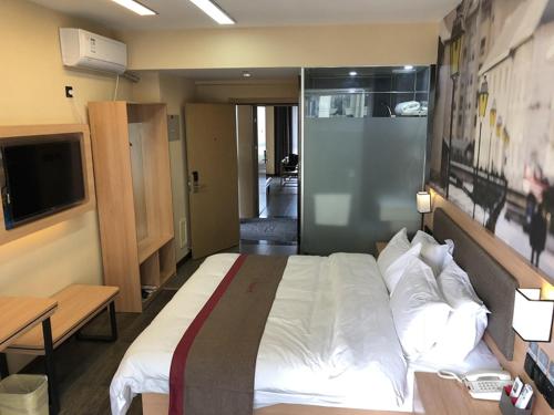 ein Schlafzimmer mit einem großen Bett und einem TV in der Unterkunft Thank Inn Plus Hotel Hebei Langfang Art Avenue Danfeng Park Exhibition in Langfang