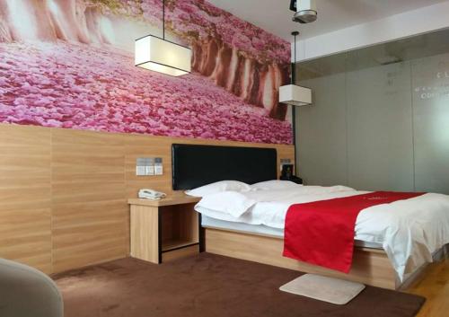 a bedroom with a large bed with a pink wall at Thank Inn Plus Hotel Shanxi Yanan Ganquan County North Railway Station in Yan'an