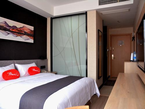 1 dormitorio con 1 cama blanca grande con almohadas rojas en Up And In Fujian Fuzhou Minhou County Shangjie Town Fuzhou University City, en Fuzhou
