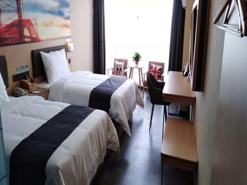 a hotel room with two beds and a desk at Thank Inn Plus Hotel Henan Kaifeng Tongxu county Renmin Road in Kaifeng