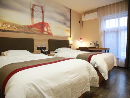 a hotel room with two beds and a painting on the wall at Thank Inn Plus Hotel Shandong Jining Qufu City Sankong Tourist Center in Jining