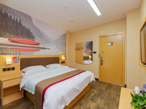 a bedroom with a large bed and a painting on the wall at Thank Inn Plus Hotel Sichuan Chengdu Jianyang Dongcheng Huafu in Chengdu