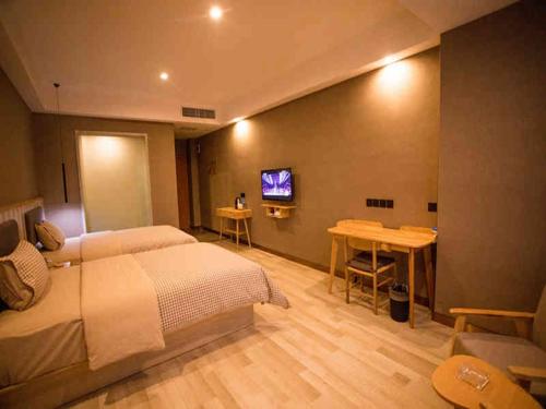 a bedroom with a bed and a tv on a wall at Up And In Yunnan Dehongzhou Mangshi Street in Mangshi