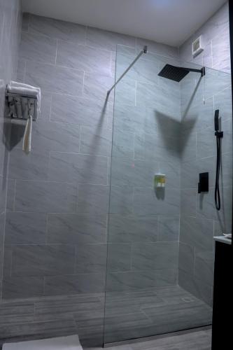 a shower with a glass door in a bathroom at BON Hotel Ikeja Residence in Ikeja