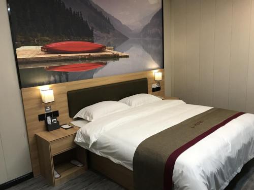 um quarto com uma cama grande e uma pintura na parede em Thank Inn Plus Hotel Anhui Huibei Xiangshan District Suixi Middle Road em Huaibei