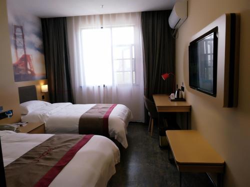 SuizhouにあるThank Inn Plus Hotel Hubei Suizhou Zengdu District Mingzhu Plazaのベッド2台、デスク、窓が備わるホテルルームです。
