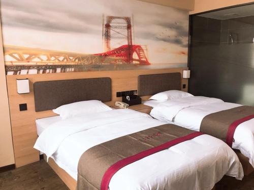 2 camas en una habitación de hotel con un cuadro en la pared en Thank Inn Plus Hotel Shandong Weihai Rongcheng City Chengshan Avenue Rt-mart, en Weihai