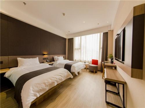 a hotel room with two beds and a flat screen tv at Thank Inn Plus Hotel Hebei Shijiazhuang High-tech Zone Torch Plaza in Shijiazhuang