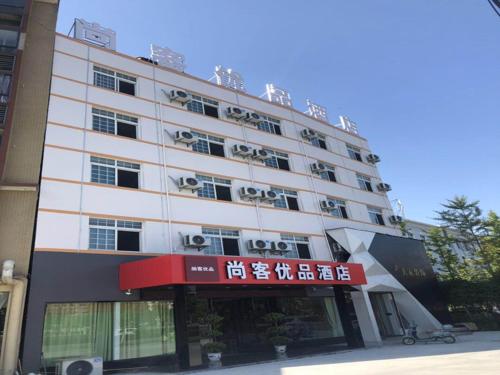 un edificio blanco con un cartel delante en Up And In HuBei Jingzhou Jiangling xian Jiangling Road, en Jingzhou