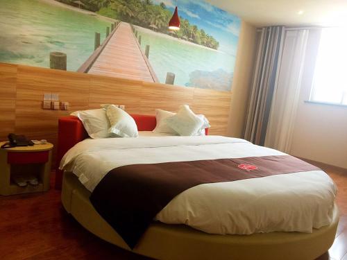 een slaapkamer met een groot bed en een schilderij aan de muur bij Thank Inn Plus Hotel Shandong Jining High-tech District Huangtun Plaza Commercial Building in Jining