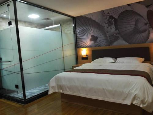 a bedroom with a large bed and a glass wall at Thank Inn Plus Hotel Shandong Heze Development Zone Huaihe Road in Heze