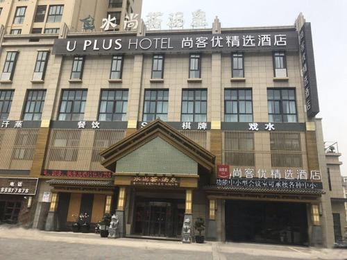a building with a sign on the front of it at Thank Inn Plus Jiangsu Zhenjiang Jiangkou District Hongdou Square in Zhenjiang