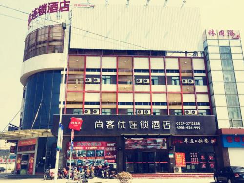 a large building with writing on the front of it at Thank Inn Plus Hotel Shandong Jining High-tech District Huangtun Plaza Commercial Building in Jining