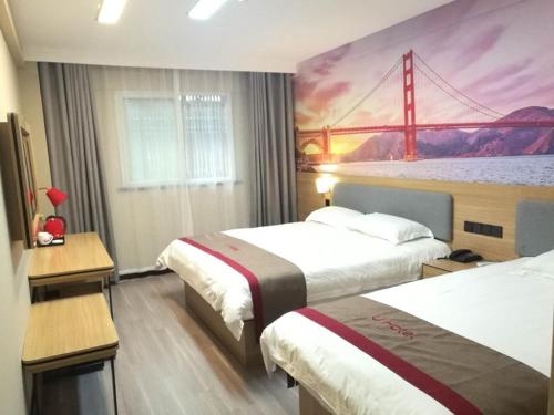 una habitación de hotel con 2 camas y una pintura de un puente en Thank Inn Plus Hotel Henan Shangqiu Suiyang District Shenhuo Avenue South, en Shangqiu