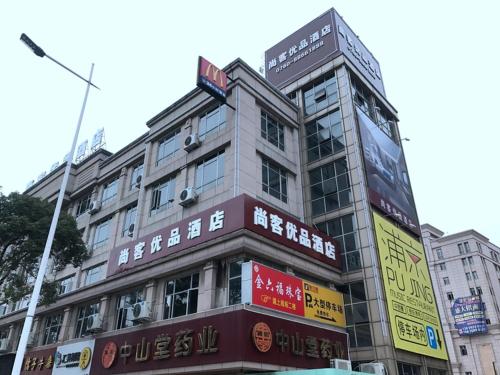 un grand bâtiment avec des panneaux sur son côté dans l'établissement Up And In Guangdong Zhongshan West District Caihong Street, à Zhongshan