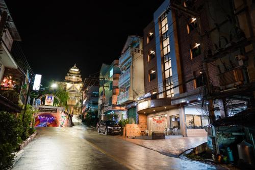 an empty city street at night with a building at Betong Hello Hotel in Betong