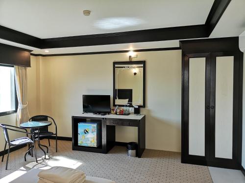 a hotel room with a desk and a mirror at Betong Hello Hotel in Betong