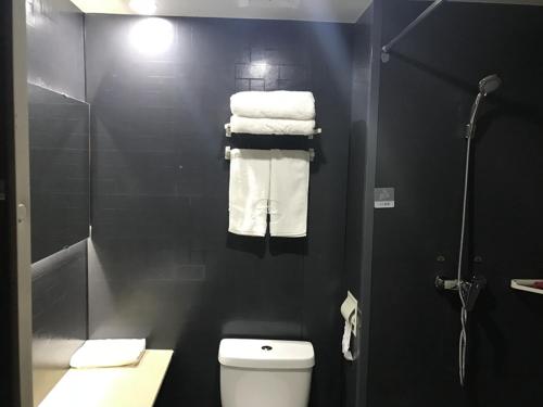 a bathroom with a shower and a toilet and towels at Thank Inn Plus Hotel Jiangsu Taizhou Gaogang Port Middle School in Taizhou