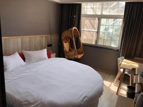 Un dormitorio con una cama con una mochila. en Up And In HuBei Jingzhou Jiangling xian Jiangling Road, en Jingzhou