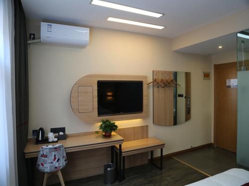 a room with a desk and a tv on the wall at Thank Inn Plus Hotel Shandong Weifang Shouguang City Shengcheng Street Daily Newspaper Office in Weifang